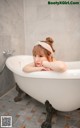 A woman laying in a bathtub in a bathroom.