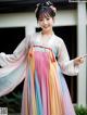 A woman in a colorful hanbok is posing for a picture.