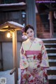 A woman in a kimono standing in front of a building.