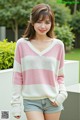 a woman wearing a pink and white striped sweater