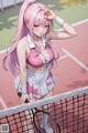 A woman with pink hair holding a tennis racket on a tennis court.