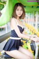 A woman in a black and white dress sitting on a bike.