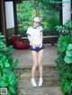 A woman in a white shirt and blue shorts posing for a picture.