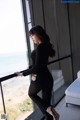 A woman standing on a balcony looking out at the ocean.