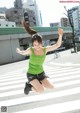 A woman jumping in the air on a crosswalk.