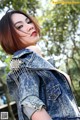 A woman in a denim jacket posing for a picture.